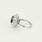 Bague jupe en or blanc centrée d'une émeraude de 2,05ct dans un double entourage de diamants