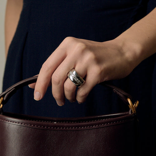 Importante Bague composée d’un large jonc bombé en or gris et diamants