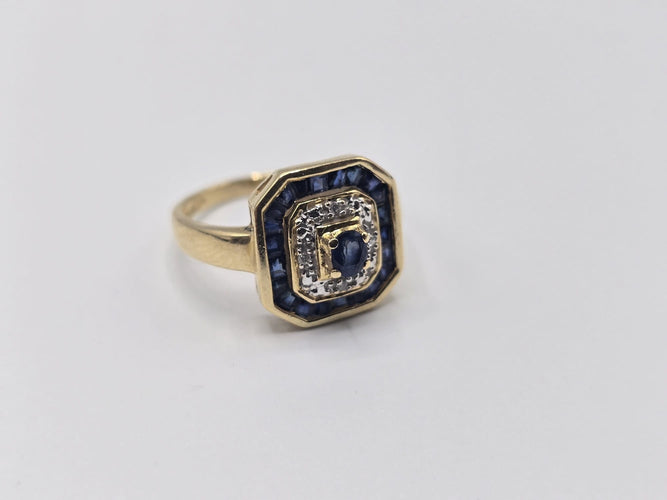 Bague 56 Bague OR Jaune 18k sertie d'un Saphir central, d’éclats de diamants et d'un contour de saphir baguettes 58 Facettes 1-0000448/2