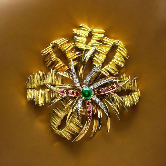 Broche MELLERIO - Broche en or jaune, le centre orné d’émeraude, de rubis et de diamants. 58 Facettes