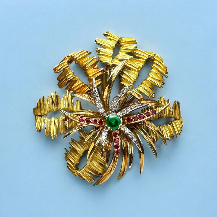 Broche MELLERIO - Broche en or jaune, le centre orné d’émeraude, de rubis et de diamants. 58 Facettes