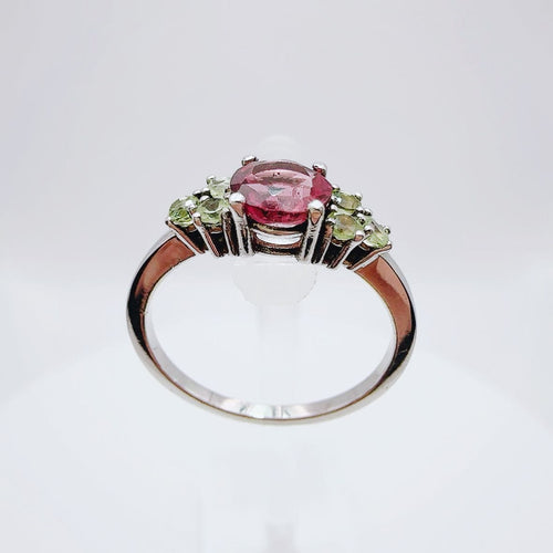 Bague en or blanc de style vintage avec tourmaline ovale et péridots.