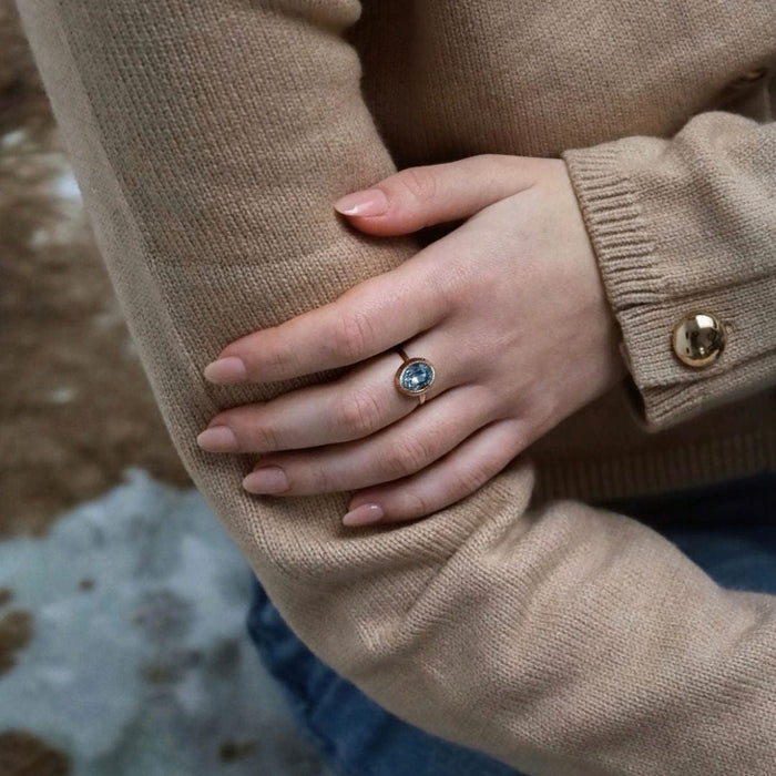 Bague solitaire en or rose avec topaze ovale bleue