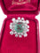 Bague 55 Magnifique bague en or blanc avec une émeraude centrale et des diamants tout autour. 58 Facettes