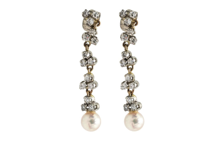 Une paire de boucles d'oreilles unique avec perles et diamants.