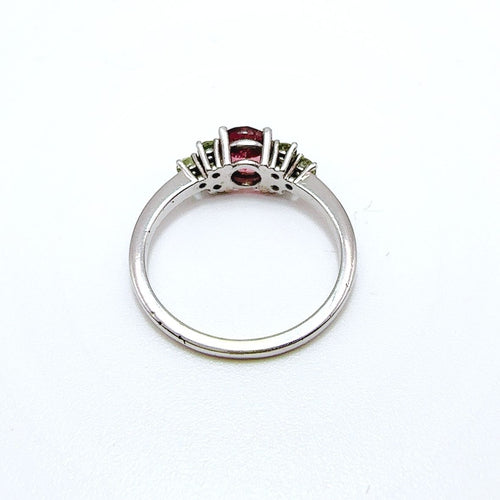 Bague en or blanc de style vintage avec tourmaline ovale et péridots.