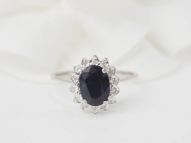 Bague marguerite en or blanc, diamants et saphir ovale 58 Facettes 26804