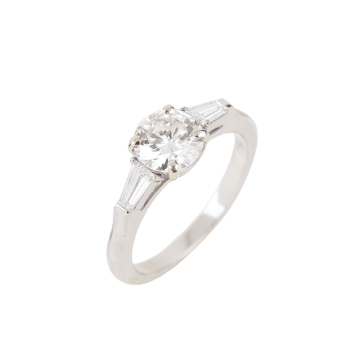 Bague Graff - Bague en or blanc 18 carats sertie d'un diamant central brillant et de diamants latéraux trapézoïdaux. 58 Facettes 130281