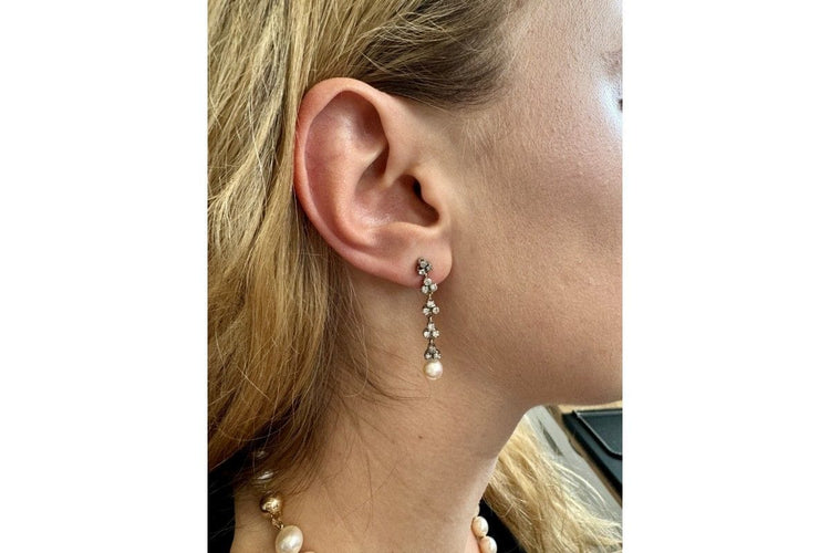 Une paire de boucles d'oreilles unique avec perles et diamants.