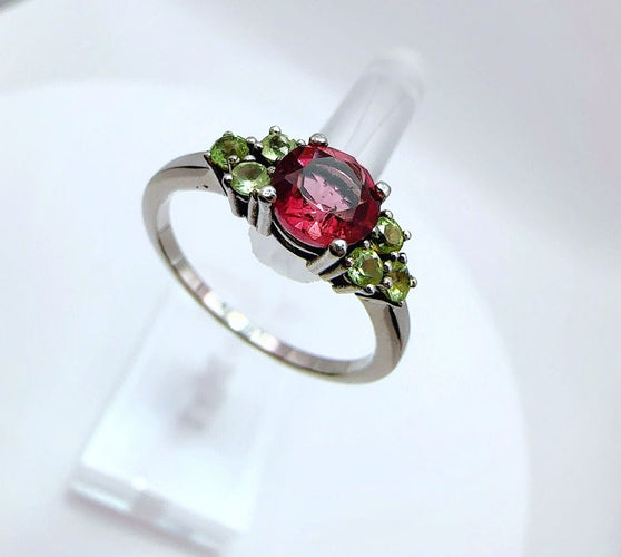 Bague en or blanc de style vintage avec tourmaline ovale et péridots.