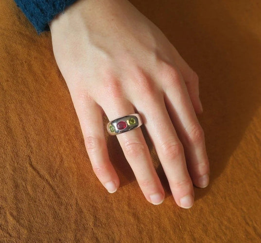 Bague 57 Bague jonc en or blanc, rubis et péridots 58 Facettes