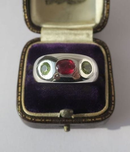 Bague 57 Bague jonc en or blanc, rubis et péridots 58 Facettes