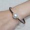 Bracelet Bracelet en acier brun avec perle australienne 58 Facettes PUV209