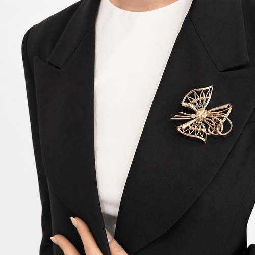 Broche Broche nœud stylisé en or jaune 18 carats, diamants et émeraudes 58 Facettes 36314