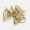 Broche Broche nœud en or jaune, diamants et émeraudes 58 Facettes 36314