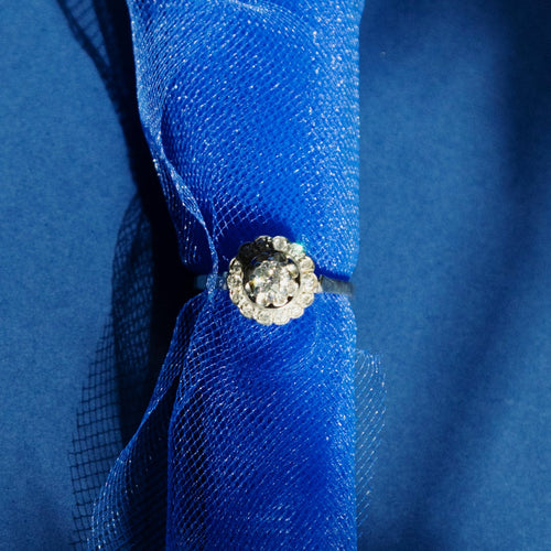 https://cdn.shopify.com/s/files/1/0943/8576/6747/files/bague-marguerite-or-blanc-diamants-fond-bleu.jpg?v=1792764035