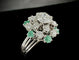 Bague 59 Bague marguerite en or blanc, diamants et émeraudes 58 Facettes Bague 04