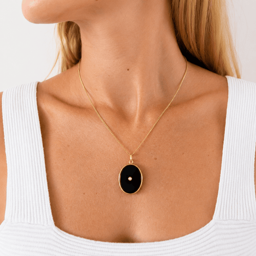 Pendentif Pendentif médaillon porte-souvenir en or jaune, onyx et perle 58 Facettes