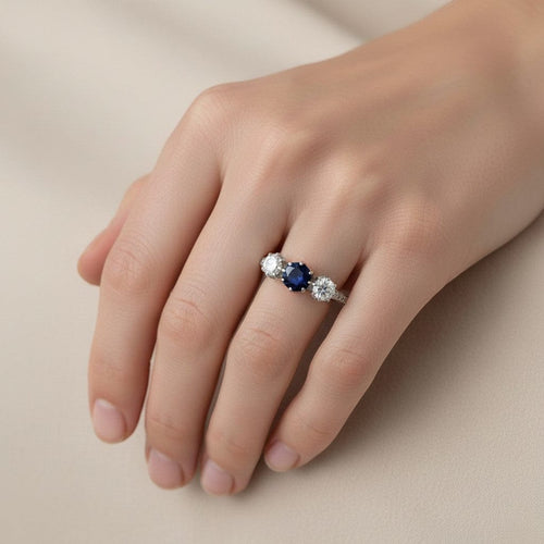 https://cdn.shopify.com/s/files/1/1015/8633/8124/files/antique-art-deco-18k-white-gold-sapphire-diamond-trilogy-ring-worn.jpg?v=1784916671