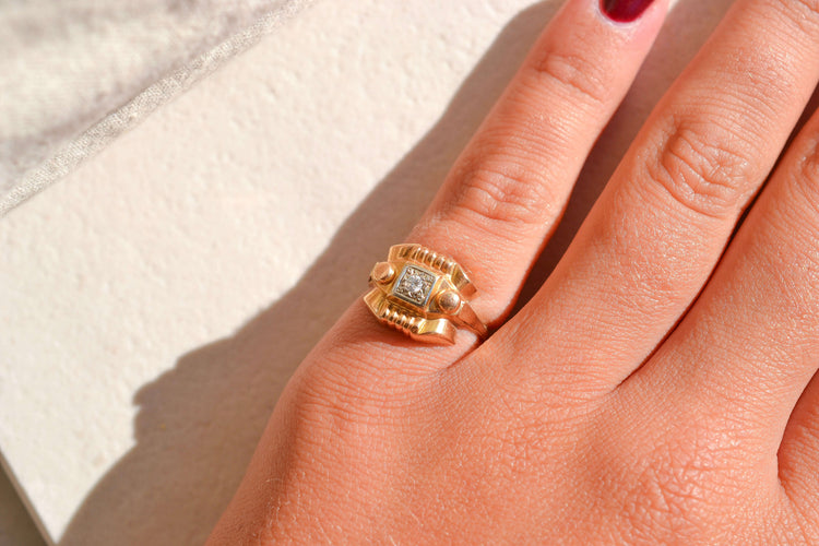 https://cdn.shopify.com/s/files/1/0963/7950/2920/files/bague-tank-ornee-d-un-diamant-central-bague-de-seconde-main.jpg?v=1790673229