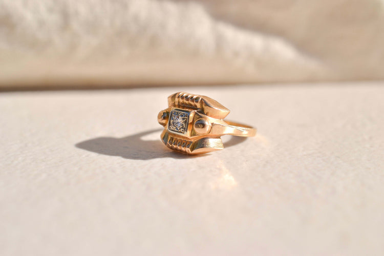 https://cdn.shopify.com/s/files/1/0963/7950/2920/files/bague-tank-ornee-d-un-diamant-central-bague-vintage.jpg?v=1790673161