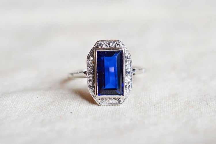 https://cdn.shopify.com/s/files/1/0963/7950/2920/files/bague-octogonale-art-deco-en-or-blanc-sertie-d-un-saphir-synthetique-verneuil-et-de-diamants-taille-rose-bague-cadeau-femme.jpg?v=1790672259