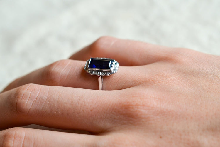 https://cdn.shopify.com/s/files/1/0963/7950/2920/files/bague-octogonale-art-deco-en-or-blanc-sertie-d-un-saphir-synthetique-verneuil-et-de-diamants-taille-rose-bague-retro.jpg?v=1790672296