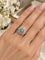 Anillo de diamantes entre flores elegantes.png