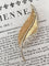 Broche Broche plume en or jaune et blanc 18k avec diamants taille rose 58 Facettes 307
