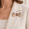 Broche Broche nœud en or rosé 18 carats sertie de rubis 58 Facettes 1.0001703/1