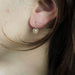 Fine white sapphire flower sleeper earrings 58 Facettes 19-456I